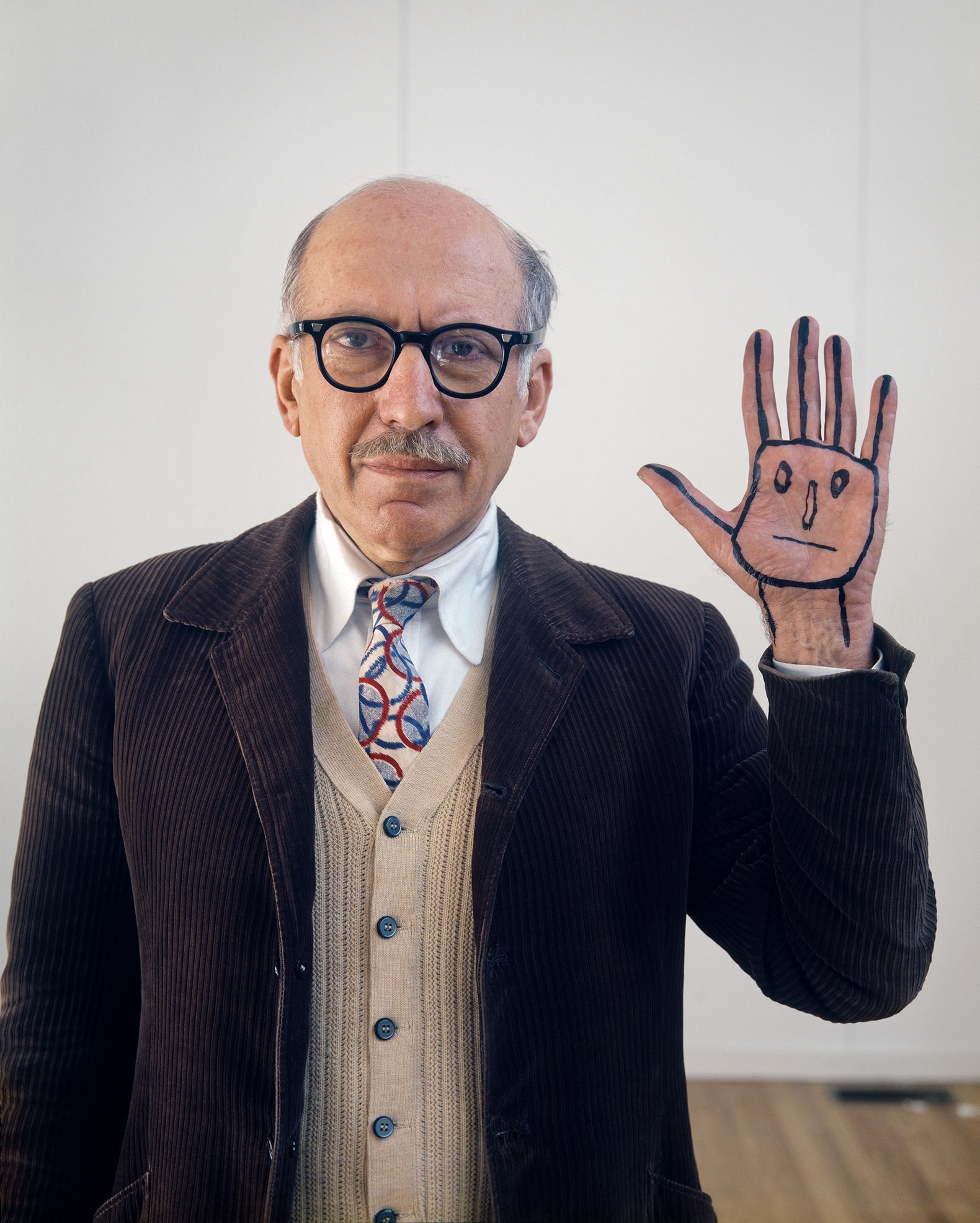 Saul Steinberg con una cara en su mano, Long Island, 1978 . Fotografía por Evelyn Hofer.