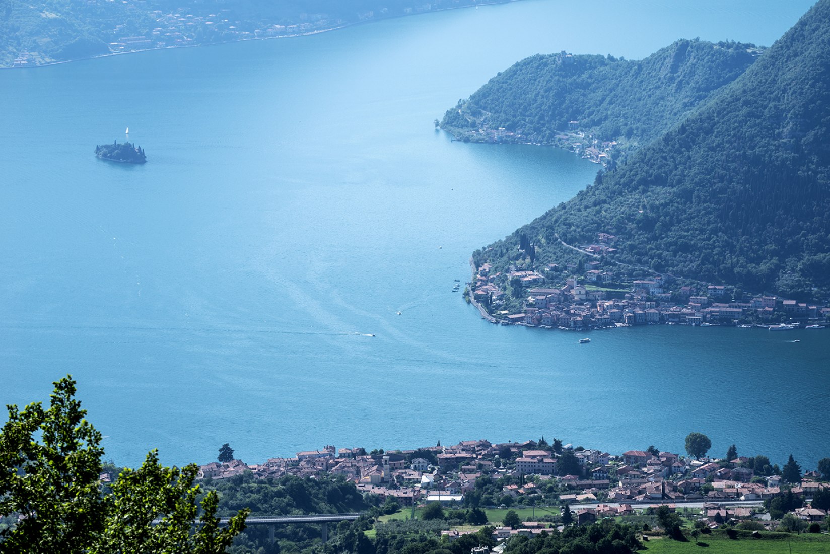 Lake Iseo with the town of Sulzano in the foreground, the island of Monte Isola on the right and the island of San Paolo on the left. Image © Wolfgang Volz.