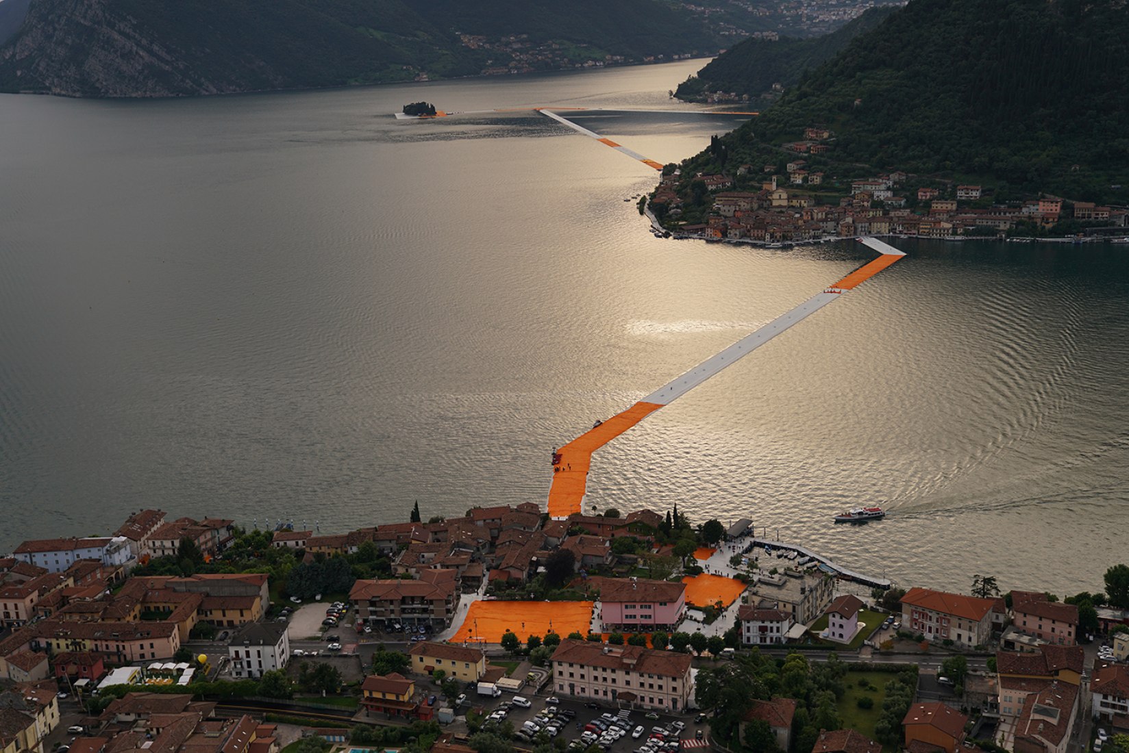 In the evening of June 15, hundreds of workers start to unfurl 1000,000 square meters of shimmering yellow fabric on the piers and pedestrian streets in Sulzano and Peschiera Maraglio. Image © Wolfgang Volz.