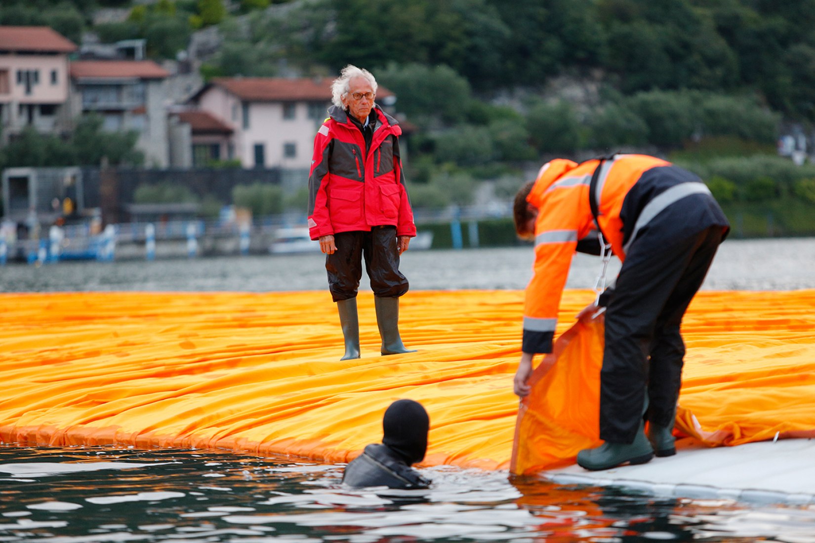 In the evening of June 15, hundreds of workers start to unfurl 1000,000 square meters of shimmering yellow fabric on the piers and pedestrian streets in Sulzano and Peschiera Maraglio. Image © Wolfgang Volz.