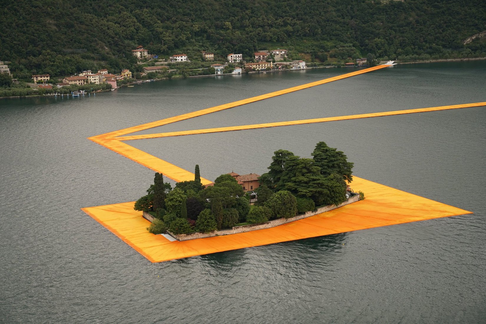 In the morning of June 16, unfurling of 1000,000 square meters of shimmering yellow fabric on the piers and pedestrian streets in Sulzano and Peschiera Maraglio is nearly completed. Image © Wolfgang Volz.