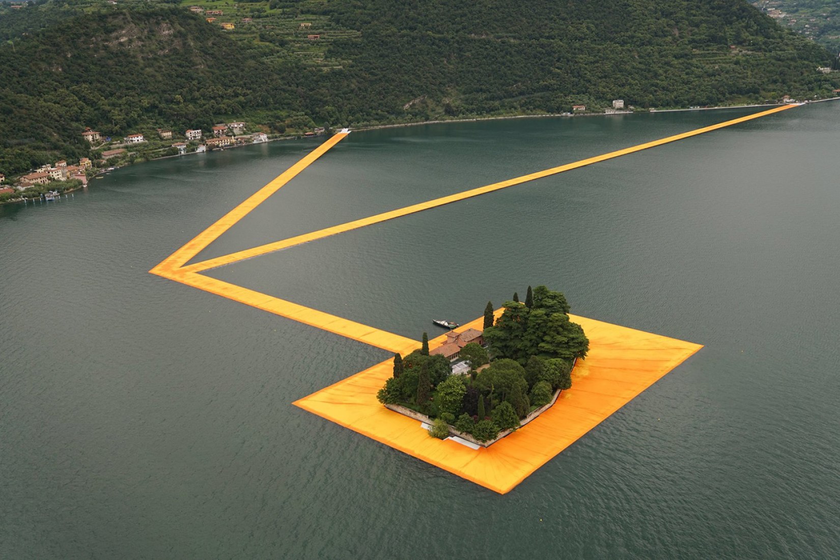 In the morning of June 16, unfurling of 1000,000 square meters of shimmering yellow fabric on the piers and pedestrian streets in Sulzano and Peschiera Maraglio is nearly completed. Image © Wolfgang Volz.