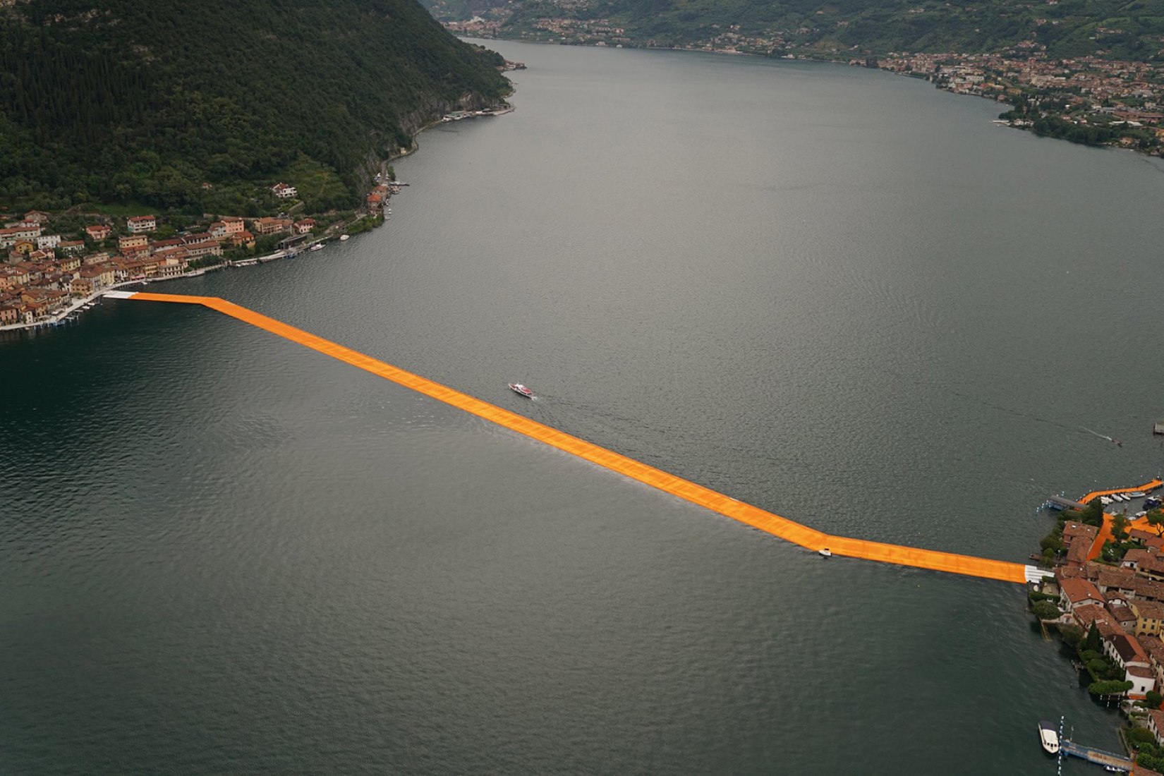 In the morning of June 16, unfurling of 1000,000 square meters of shimmering yellow fabric on the piers and pedestrian streets in Sulzano and Peschiera Maraglio is nearly completed. Image © Wolfgang Volz.