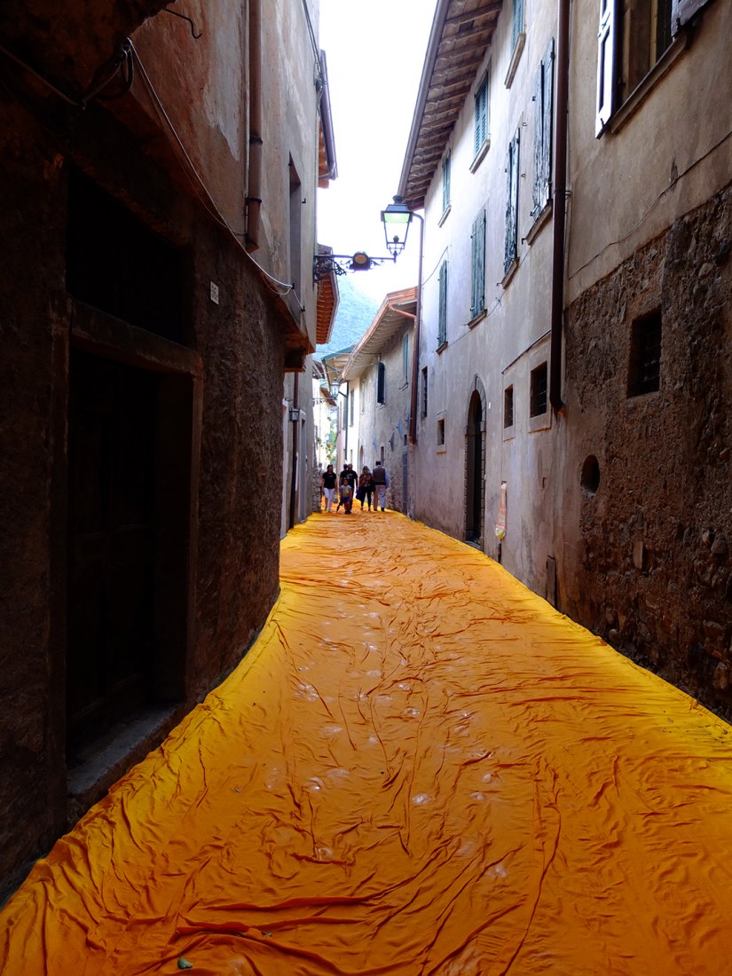 In the morning of June 16, unfurling of 1000,000 square meters of shimmering yellow fabric on the piers and pedestrian streets in Sulzano and Peschiera Maraglio is nearly completed. Image © Wolfgang Volz.