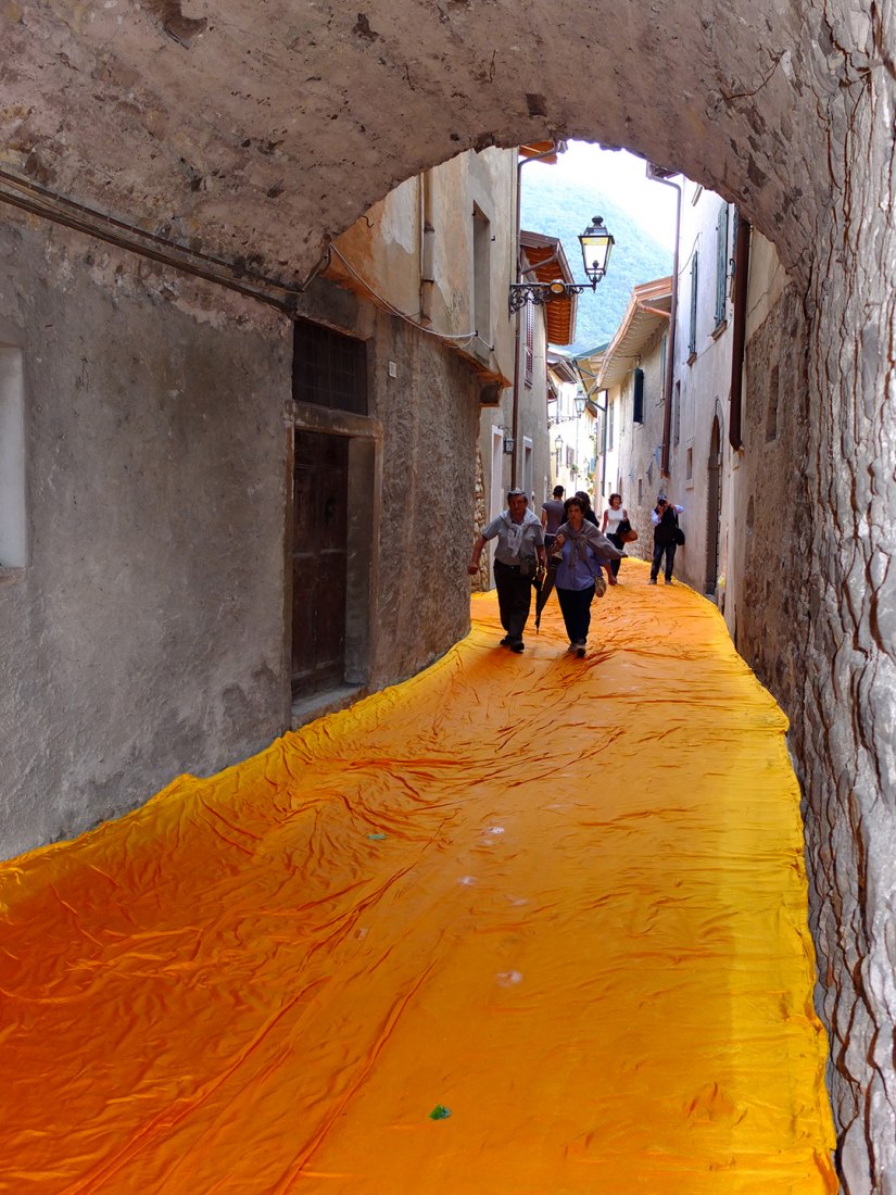 In the morning of June 16, unfurling of 1000,000 square meters of shimmering yellow fabric on the piers and pedestrian streets in Sulzano and Peschiera Maraglio is nearly completed. Image © Wolfgang Volz.