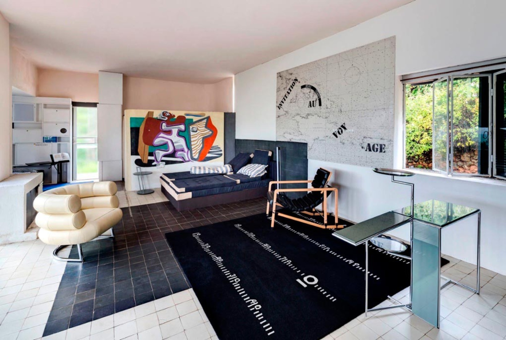 A view of the living room with furniture and rugs designed by Gray, and, on the far wall, a mural by Le Corbusier.  Photograph @ Manuel Bougot. 