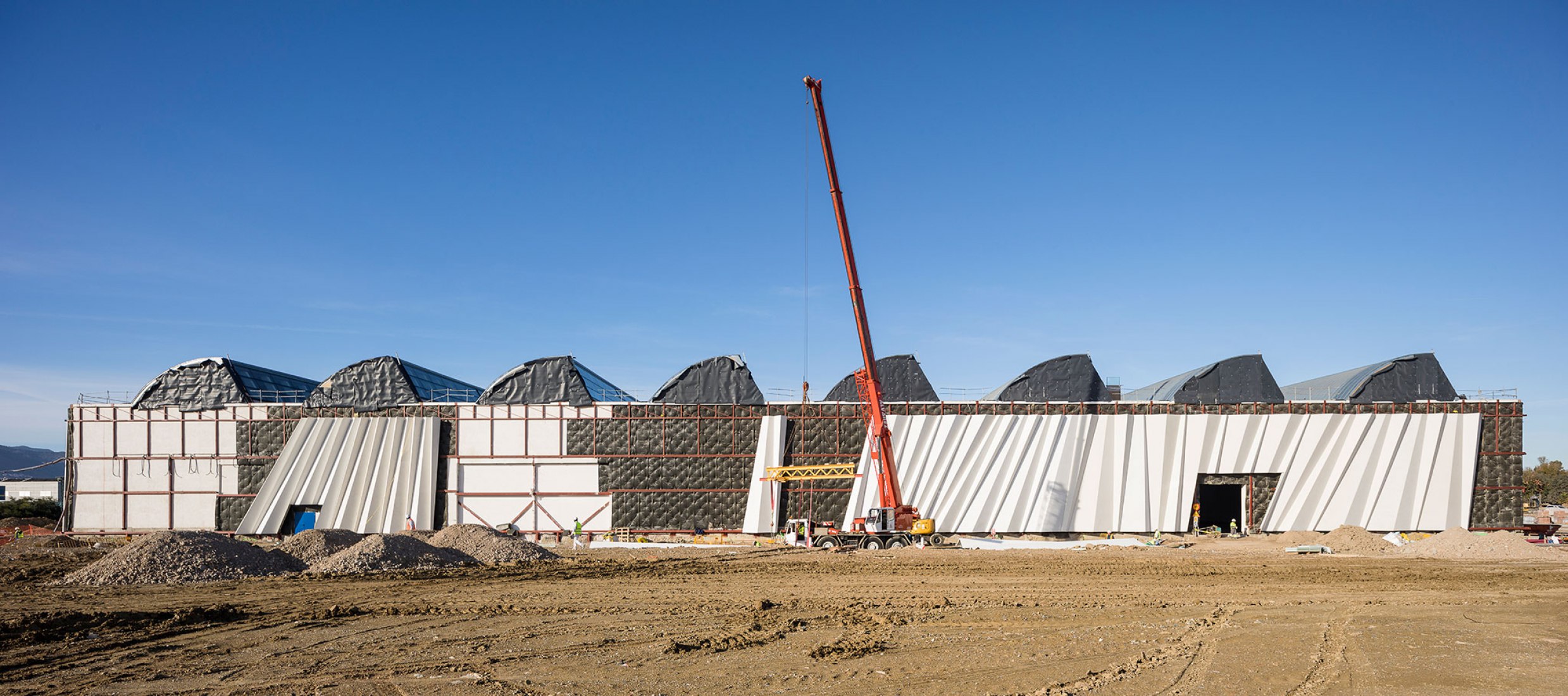 Exterior view, assembly process of the facade. Rehabilitation of the Intelhorce factory in Málaga by System Arquitectura. Photography by Fernando Alda Exterior view, assembly process of the facade. Rehabilitation of the Intelhorce factory in Málaga by System Arquitectura. Photography by Fernando Alda