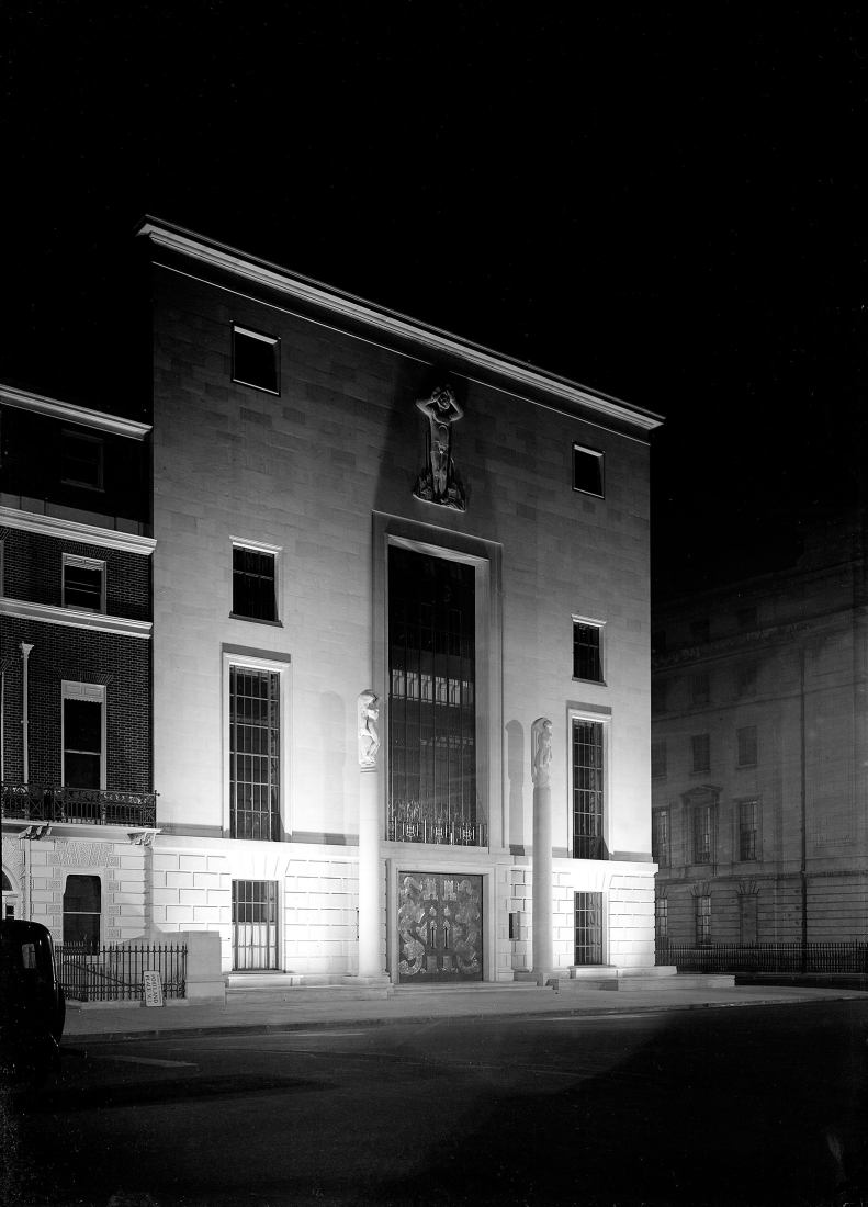 Exterior del RIBA: entrada principal del 66 Portland Place, Londres, construida expresamente para el Real Instituto de Arquitectos Británicos. Foto tomada de noche con el exterior iluminado con focos. Fotografía por George Gray Wornum, 1934.